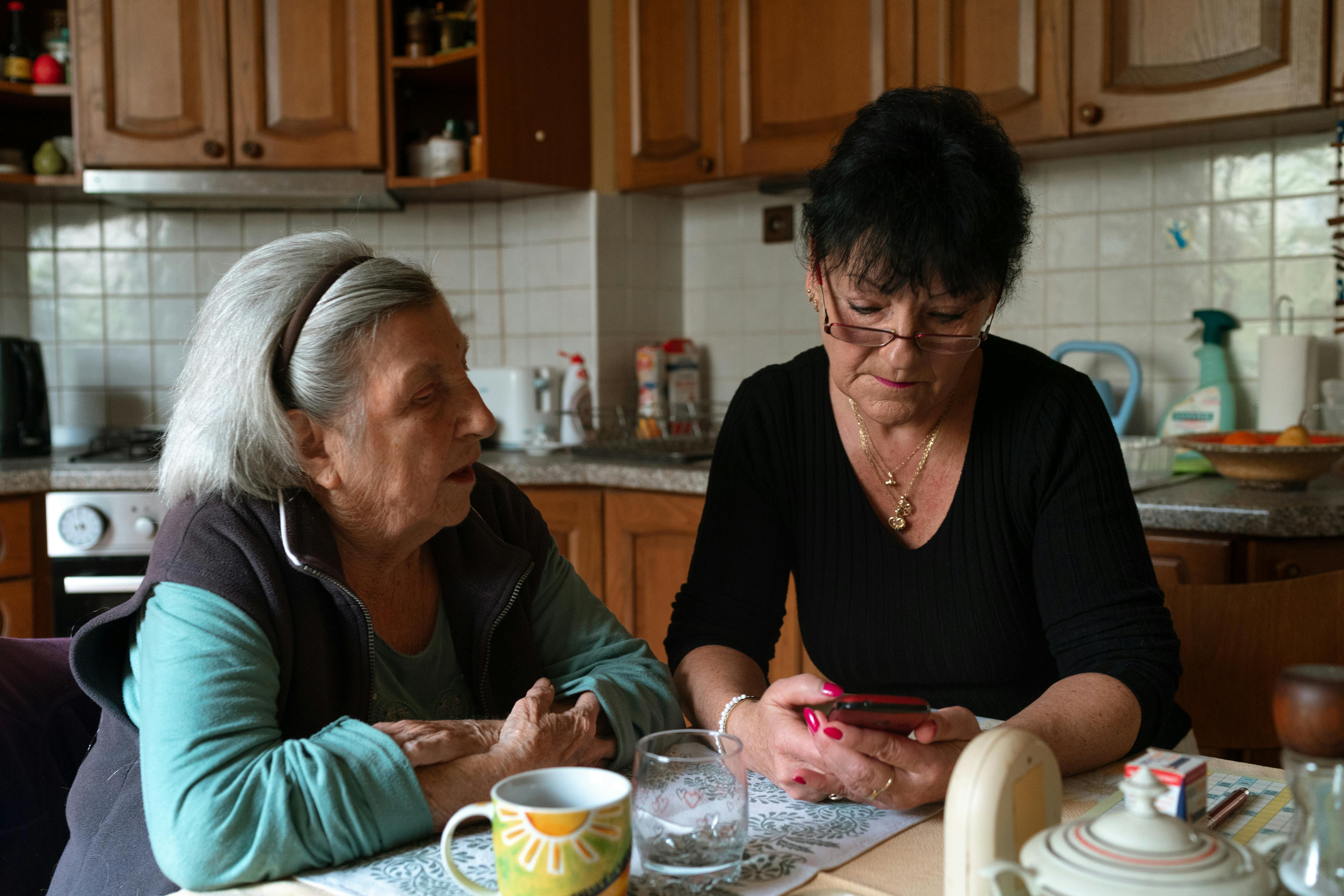 Caregiver and older adult reviewing something together at home
